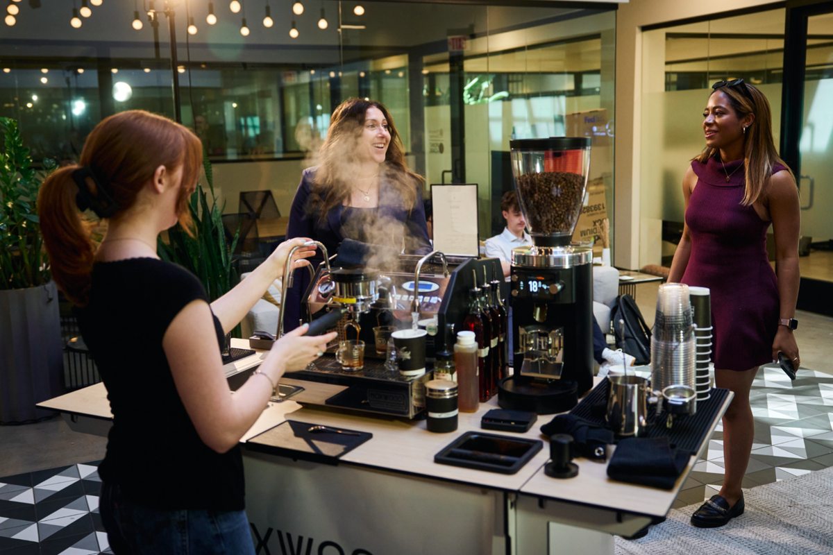 A Boxwood barista serving guests from the coffee cart at an office event